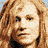 Pixelated portrait of a person with light brown hair in top-left corner, surrounded by distorted text and a TNT logo on black background.