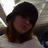 Pixelated static image of a person with dark hair and light skin wearing a white top against a blurred background.