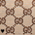 A static pattern of interlocking brown G-shaped symbols on a beige background with one black heart symbol in the bottom-left corner.