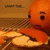 Animated orange character with a sad expression, holding sliced oranges and a glass of juice against a brown background.