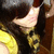 Pixelated image showing a partial figure with light skin, dark hair, and yellow clothing against a brown background.