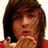 Pixelated image of a person with brown hair in a red shirt, hands near face, on blue background with red text.