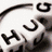 A static image showing a white cube with black 'HUG' text, two cartoon figures kissing with a heart above them, and a yellow square with 'a kiss' text and a heart symbol.