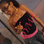 A person in a black crop top with pink text and pink trim lies on a gray surface, viewed from above.