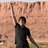 Two identical figures in black shirts stand against a rocky cliff background, each raising one arm; blue pixelated text reads "bet on it" above the right figure.