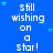 Blue background with light blue stars and repeated white text reading 'still wishing on a star!' in pixelated font.