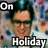 A 48x48 pixel animated contact sheet showing two side-by-side frames of a person with dark hair and glasses, wearing a light-colored shirt against a blurred background with blue and red dots, with "On" text at top corners and "Holiday" text at bottom center.