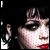Pixelated close-up of a person's face with dark hair, red lips, and a black background, showing partial facial features and a white rectangular shape on the left.