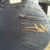 A static image of a person's lower back and buttocks in gray pants with visible creases, set against an indistinct background.