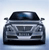 Pixelated front view of a dark gray sedan with a black roof, silver grille, and headlights, set against a light blue gradient background.