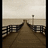 Pixelated image of a wooden boardwalk extending toward a distant horizon with railings on both sides, overlaid with blue text reading "Under the boardwalk" and "boardwalk".