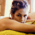 Pixelated image of a person with dark hair tied up, resting their head on a yellow surface with a blurred background.