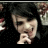 A pixelated image shows a person with dark hair holding their hand near their face, next to red '<3' symbols on black background.