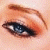 A close-up of a human eye with brown eyeliner and eyeshadow, next to green text reading 'Original Icons .com' on a dark background.