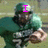 A football player in a green uniform and helmet holding a ball, with pink text overlays changing across frames.