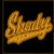 A pixelated orange shape resembling a banana with blue text 'SHADY UNIT' on black background, static image.