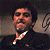 A split-frame contact sheet showing a pixelated image of Al Pacino on the left and green text reading "Original Icons .com" on the right against a dark background.