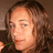 Pixelated image of a person with curly brown hair holding a green object near their mouth, next to pink text reading 'i love alexis' on a light background.