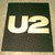 Static pixel art icon with large light yellow 'U2' text on dark green background, bordered by beige frame.