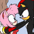 Pixelated image of two cartoon characters in close embrace, one pink with red accents, the other black with yellow beak and red crest.