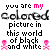 Pixelated text and symbols in black, white, and pink with animated color shifts on a white background.