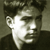 Static grayscale buddy icon of a person's face with high contrast and pixelation, showing partial facial features against a dark background.