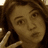 A pixelated image of a person with brown hair making a peace sign, with blue text reading "Alexis <3" at the bottom left.