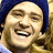 A pixelated image of two people laughing, one wearing a blue beanie and light-colored shirt, the other with long blonde hair.