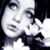 A black-and-white of nine identical showing a person with dark hair holding white flowers near their face, eyes looking upward