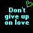 Pixelated cyan text 'Don't give up on love' with a green heart symbol above the first line, displayed against a black background.