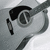 Black-and-white guitar icon with visible sound hole and strings, showing subtle pixel-level variations across four