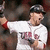 A baseball player in a white uniform with red accents and 'TIGERS' text on the chest, wearing a dark cap, holding a bat in a batting stance.