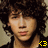 Two side-by-side pixelated images of a person with curly hair, one with a yellow '<3' symbol below the face, the other without.