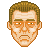 Pixelated face with brown hair, light skin tone, and orange-brown facial features against a gray background.
