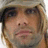 Pixelated close-up of a person's face with light brown hair, dark eyes, and pink lips against a blurred background.