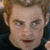 A pixelated image of a person with light brown hair and blue eyes, wearing a dark shirt, with overlaid text reading "mean just look at me" and "I'm so badass".