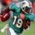 Pixelated image of a football player in teal uniform with number 19, holding a brown football on green field, next to cyan text block reading "Ted Ginn Jr. Better Than Ur Better".