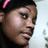 Pixelated close-up of a person's face with dark hair and a pink accessory, side profile view against light background.