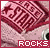 Pixelated pink and maroon patterned fabric with 'ROCKS' text in white block letters on a red banner at the bottom.