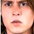 A pixelated close-up of a person's face showing eyes, nose, mouth, and dark hair against a light background.