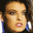 Pixelated static image of a person's face with brown hair and blue clothing, displayed as a 48x48 buddy icon on a dark background.