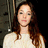 A woman with long brown hair and a white top appears in a of four with one blank