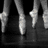 Six display ballet shoes in various styles and colors, including black-and-white, gold, red, and pink, with one showing text