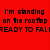 Red background with black pixelated text reading 'I'm standing on the rooftop READY TO FALL' and 'I think I'm at the edge now but I could be wrong!' next to a grayscale circular logo with heart shape and partial text.