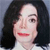 Pixelated close-up of a person with long dark hair, light skin, and red lips wearing a white top against a gray background.