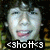 Pixelated face with wide eyes and open mouth, pink lips, dark background with green and yellow patches, white text at bottom reading '<shott<3'
