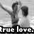 Black-and-white pixelated image of two figures with arms raised, one figure holding a microphone-like object, text "true love." at bottom.