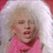 Pixelated image of a person with light brown hair wearing pink clothing against a white and red background.