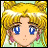 Pixelated anime-style character with blonde hair and blue eyes, wearing a green top with pink accents, next to black background with white text.