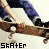A skateboarder in blue pants and black shoes performs a trick on a brown board, with text overlays changing